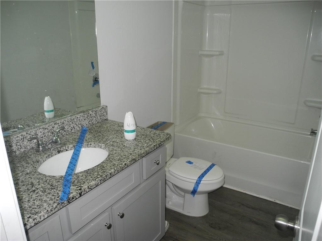 3353 Sable Elm Court Atlanta, GA 30349 - Photo 11 of 18 a bathroom with a granite countertop sink a toilet and shower
