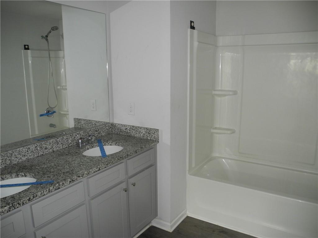 3353 Sable Elm Court Atlanta, GA 30349 - Photo 13 of 18 a bathroom with a granite countertop sink and a mirror