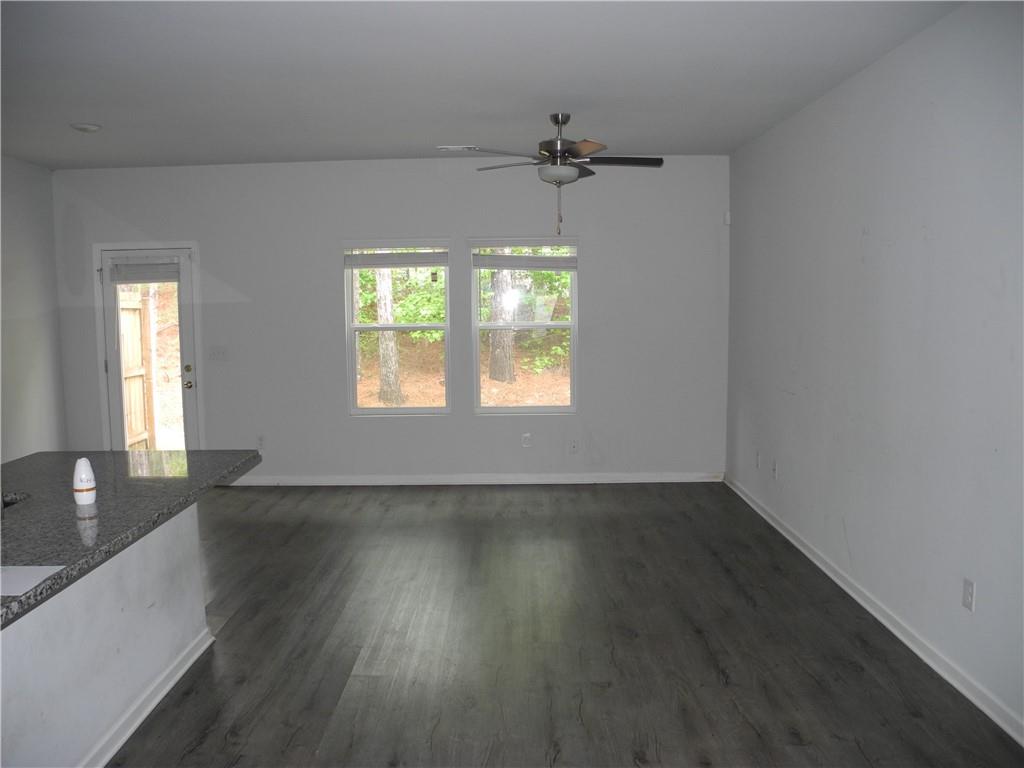 3353 Sable Elm Court Atlanta, GA 30349 - Photo 4 of 18 an empty room with wooden floor fan and windows