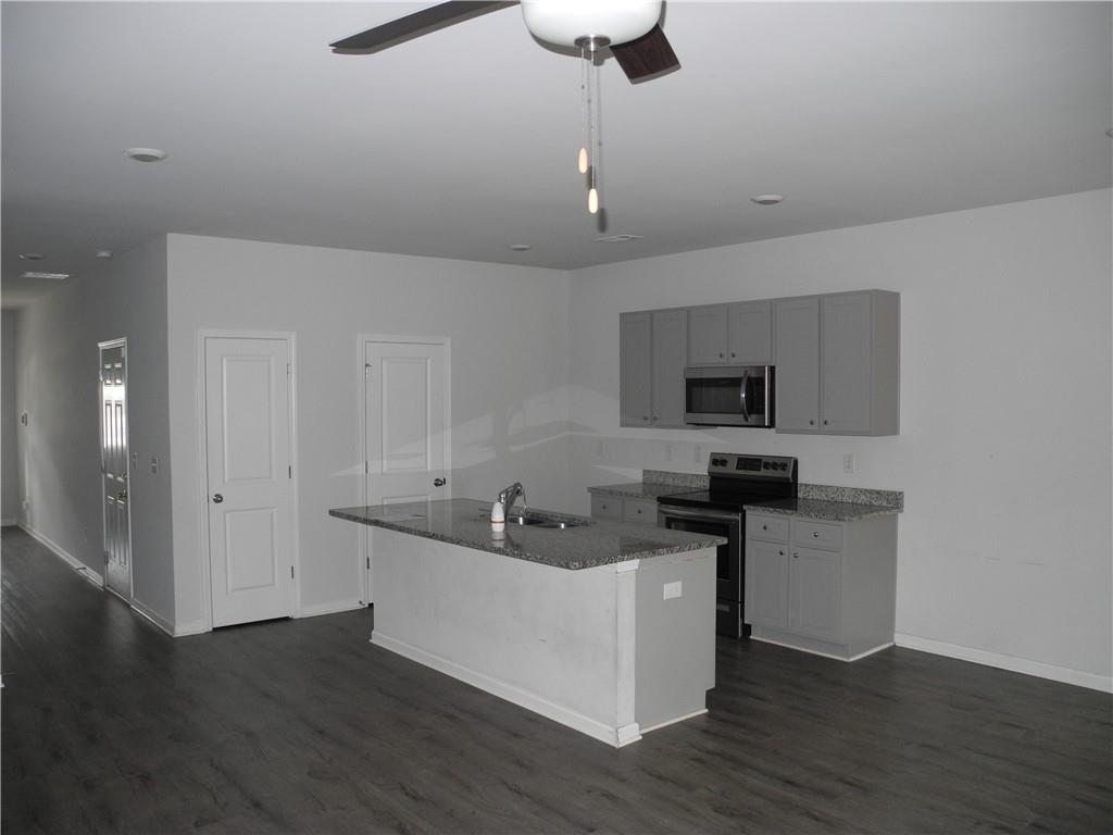3353 Sable Elm Court Atlanta, GA 30349 - Photo 5 of 18 a kitchen with stainless steel appliances granite countertop a sink a stove and a wooden floors
