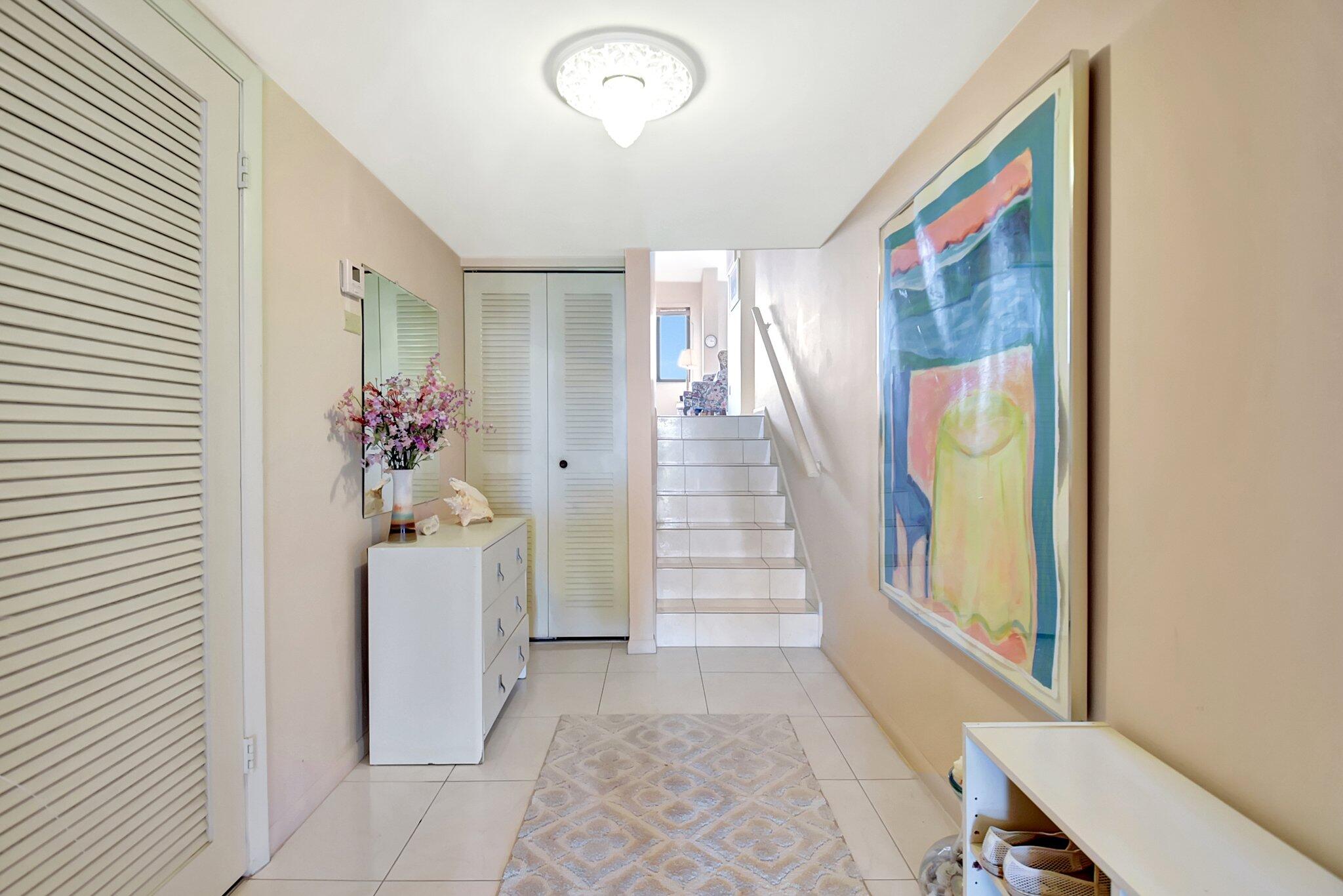 755 Dotterel Road, Unit 1512 Delray Beach, FL 33444 - Photo 15 of 48 a hallway with painting and stairs