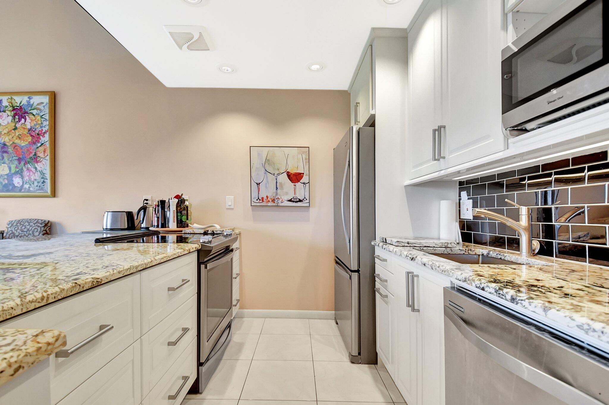 755 Dotterel Road, Unit 1512 Delray Beach, FL 33444 - Photo 3 of 48 a kitchen with stainless steel appliances granite countertop a stove and a refrigerator