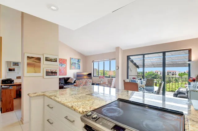 a room with stainless steel appliances kitchen island granite countertop a sink and cabinets