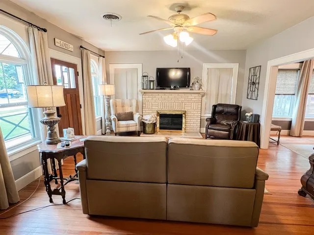 a living room with furniture a fireplace and a flat screen tv