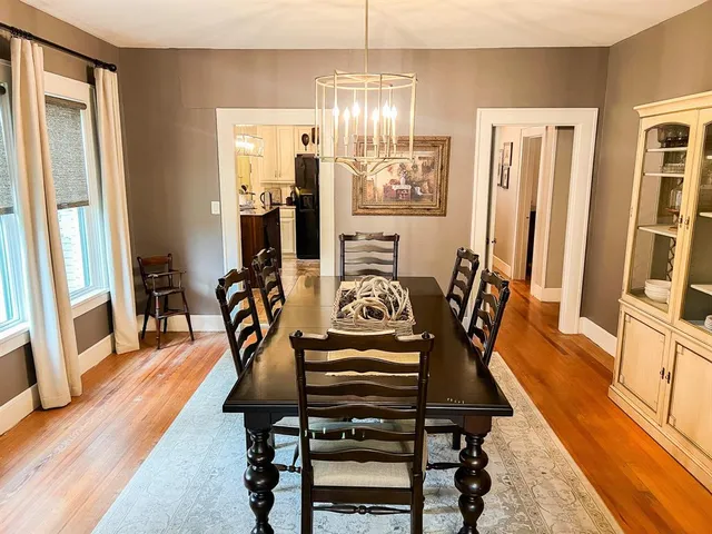 a view of a dining room with furniture a chandelier and wooden floor
