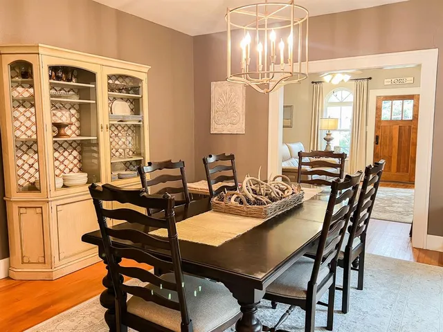 a dining room with furniture a chandelier and wooden floor