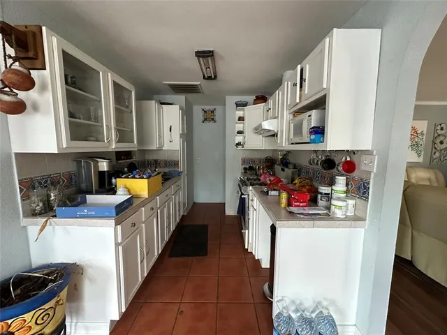 a kitchen filled with stainless steel appliances a sink and a cabinets
