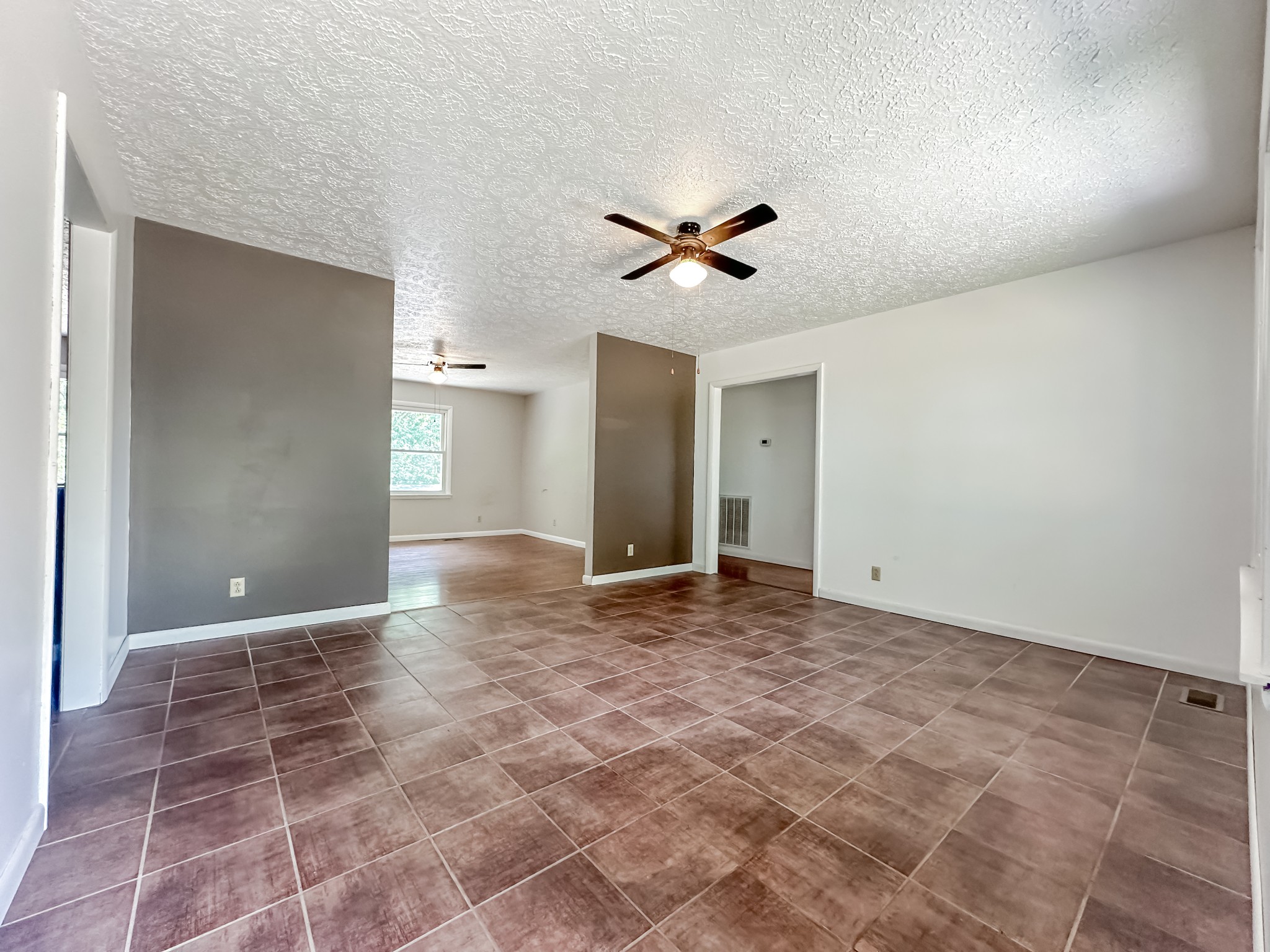 4939 Highway 49 Tennessee Ridge, TN 37178 - Photo 18 of 40 The living room has ceramic tile flooring and is open to the kitchen and dining room.