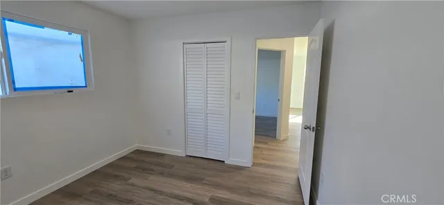an empty room with wooden floor and closet