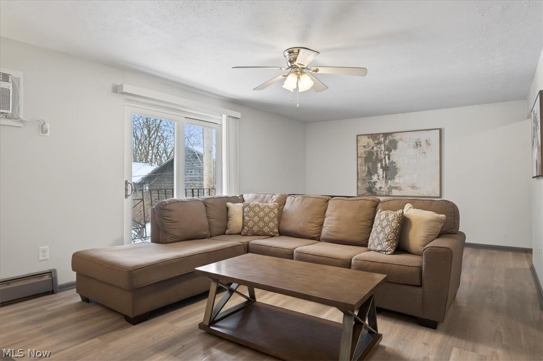 5382 Lee Road, Unit 202 Maple Heights, OH 44137 - Photo 2 of 15 Living room with wood finished floors, a ceiling fan, baseboard heating, and a textured ceiling