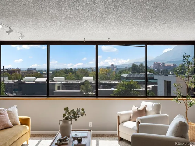 a living room with furniture kitchen view and a window