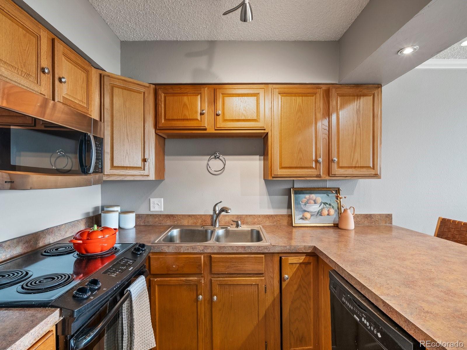 1850 Folsom Street, Unit 402 Boulder, CO 80302 - Photo 23 of 28 a kitchen with stainless steel appliances granite countertop a sink stove and cabinets