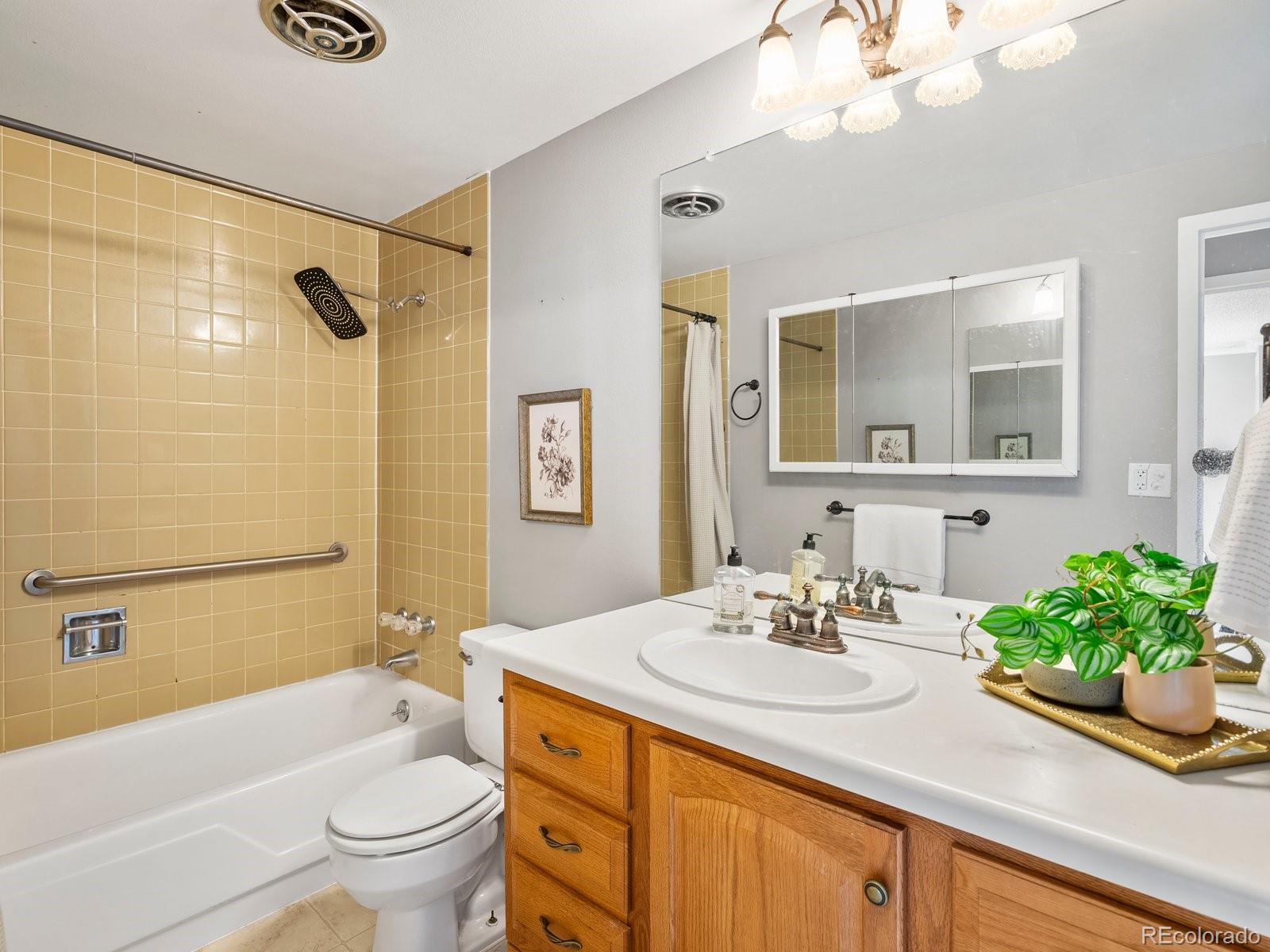 1850 Folsom Street, Unit 402 Boulder, CO 80302 - Photo 6 of 28 a bathroom with a granite countertop sink a toilet a mirror a bathtub and shower
