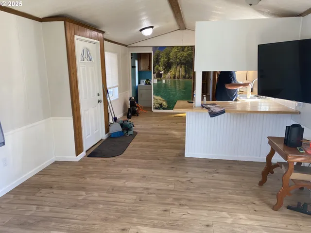 a living room with a flat screen tv furniture and a floor to ceiling window