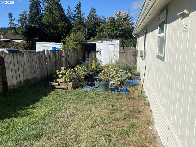 a view of a chair and table in the back yard of the house