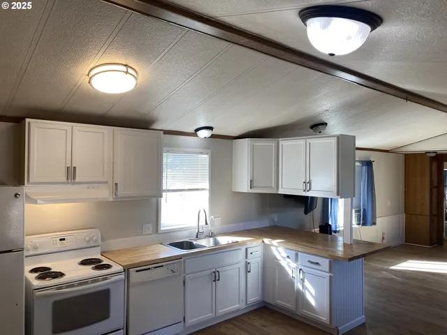 a kitchen with stainless steel appliances granite countertop a sink a stove and a refrigerator