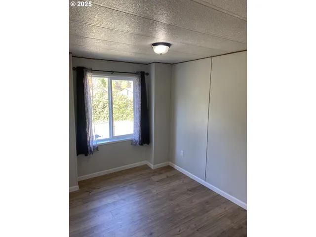 a big room with wooden floor and natural light