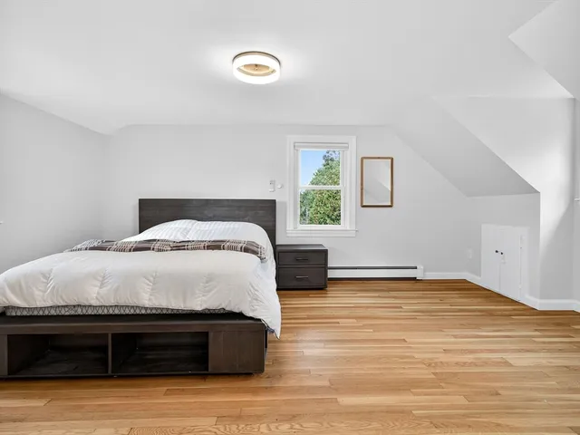 a spacious bedroom with a bed and a window