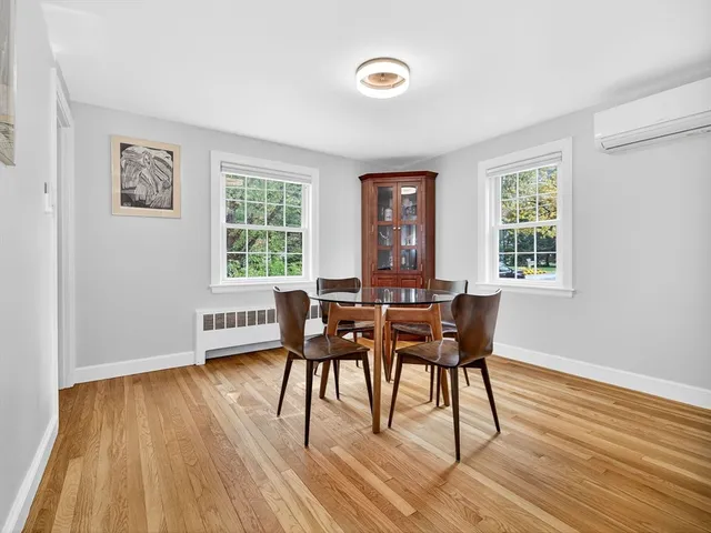 a dining room with wooden floor and a window