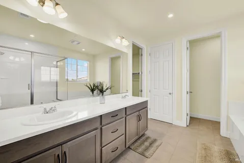 a bathroom with double vanity sinks and a mirror
