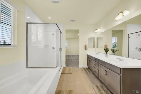 a large bathroom with a double vanity sink a large mirror and shower