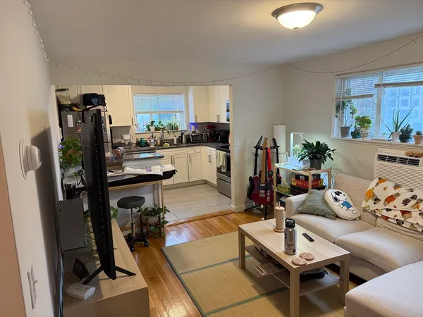 a living room with furniture a flat screen tv and a dining table