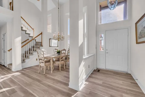 a view of a hallway with wooden floor and staircase