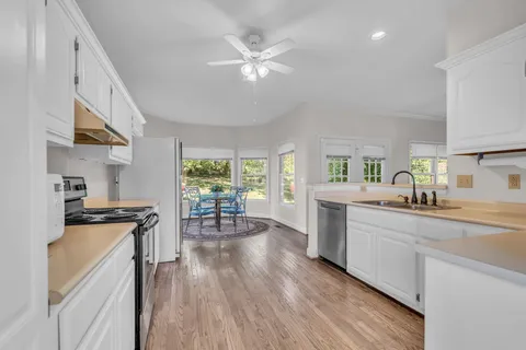 a kitchen with a table chairs stove and cabinets