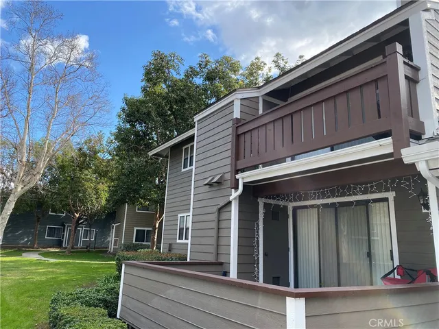 a view of a house with a small yard plants and large tree