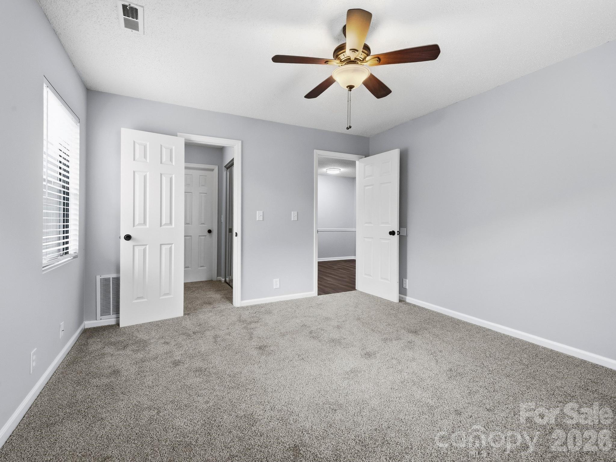 110 Heywood Road Arden, NC 28704 - Photo 14 of 22 an empty room with chandelier fan and windows