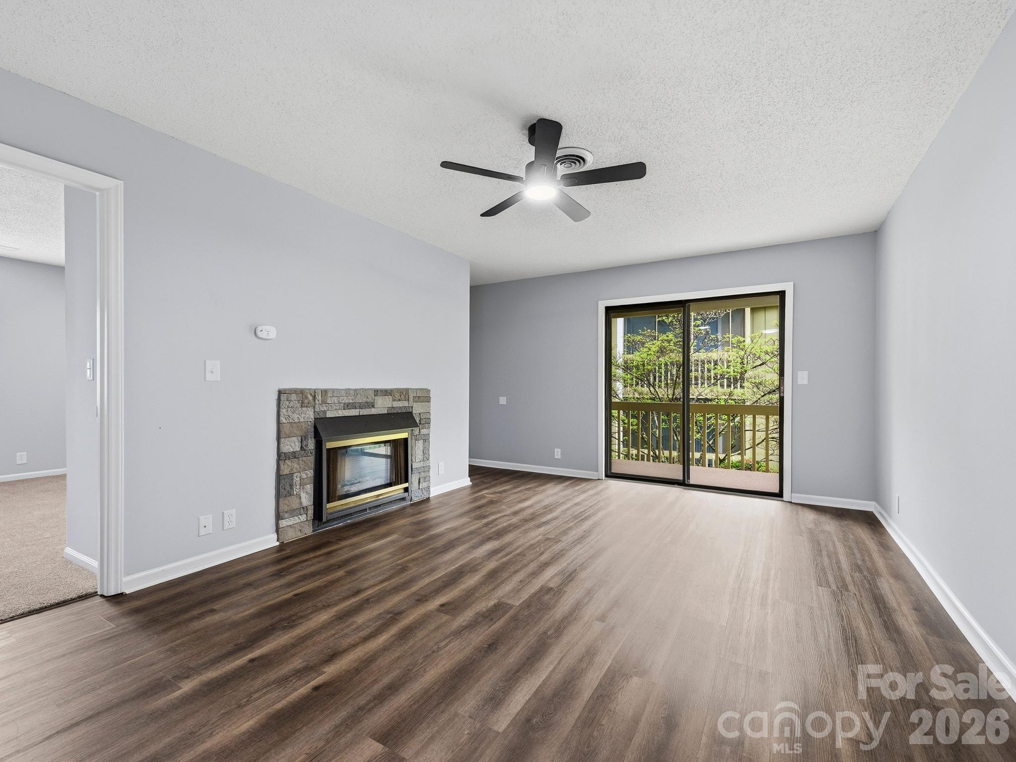 110 Heywood Road Arden, NC 28704 - Photo 3 of 22 a view of empty room with wooden floor fireplace and windows