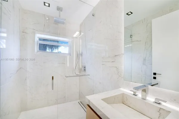 a spacious bedroom with a large bed and a flat tv screen