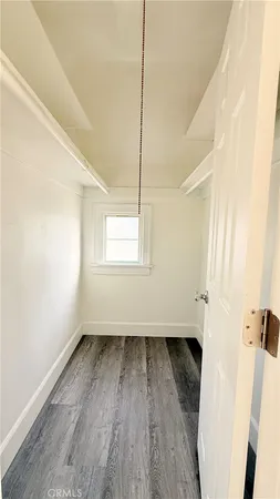 a view of a room with wooden floor and a window