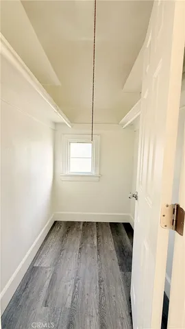 a view of a room with wooden floor and a window