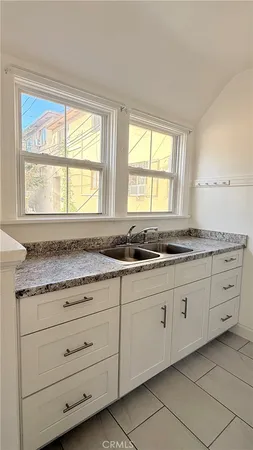 a bathroom with granite countertop a sink and a window