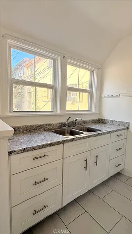 a bathroom with granite countertop a sink and a window