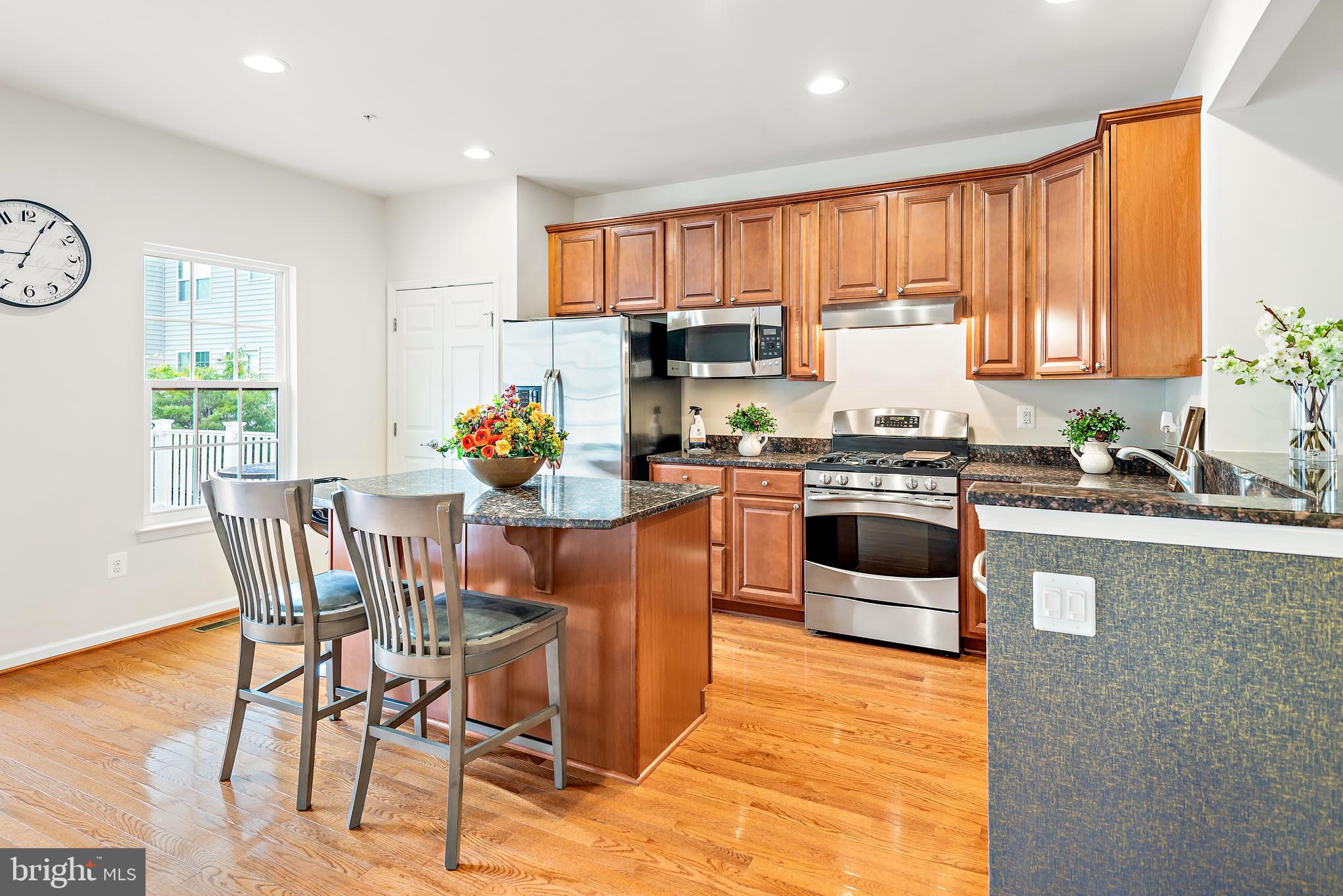 3838 Cullingworth Road Burtonsville, MD 20866 - Photo 32 of 69 a kitchen with stainless steel appliances a stove a sink a microwave a dining table and chairs
