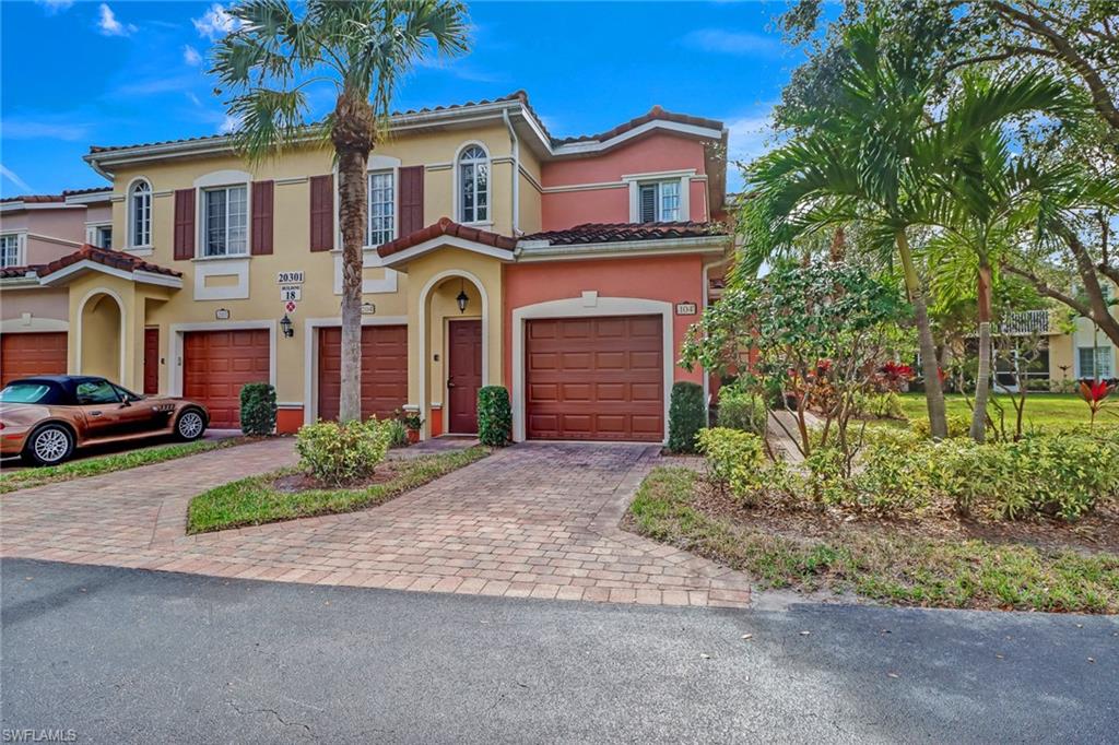 20301 Estero Gardens Circle, Unit 104 Estero, FL 33928 - Photo 1 of 43 a front view of a house with a yard and garage