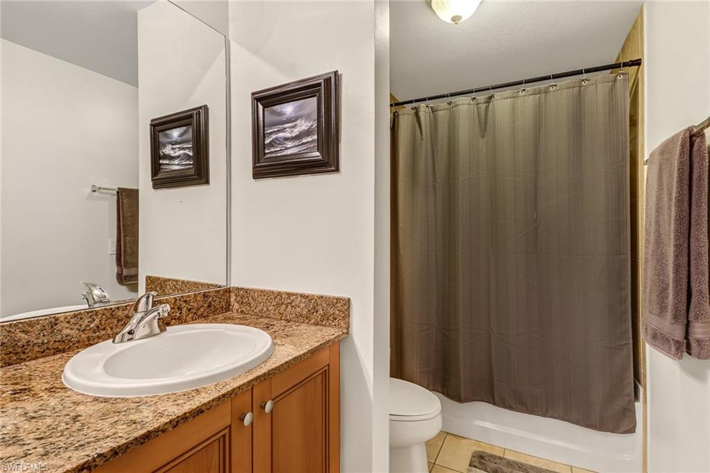 20301 Estero Gardens Circle, Unit 104 Estero, FL 33928 - Photo 14 of 43 a bathroom with a granite countertop sink and a mirror