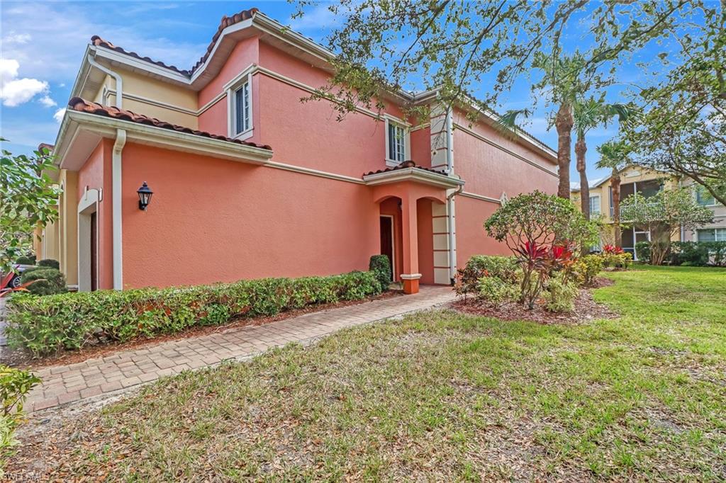20301 Estero Gardens Circle, Unit 104 Estero, FL 33928 - Photo 2 of 43 front view of a house with a yard