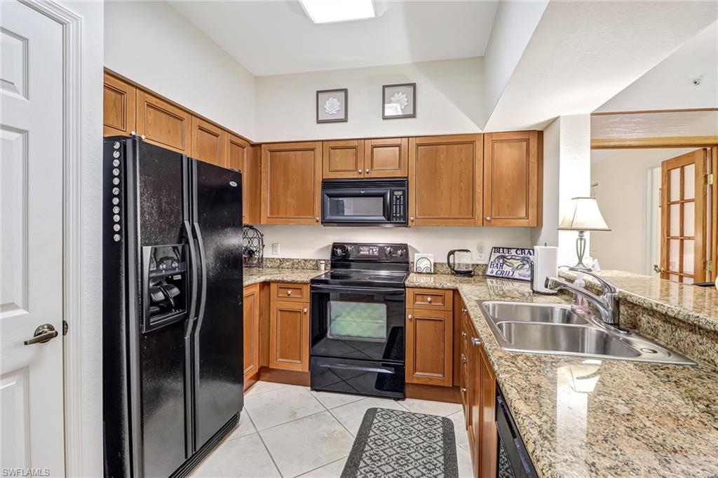 20301 Estero Gardens Circle, Unit 104 Estero, FL 33928 - Photo 3 of 43 a kitchen with stainless steel appliances granite countertop a refrigerator stove and sink