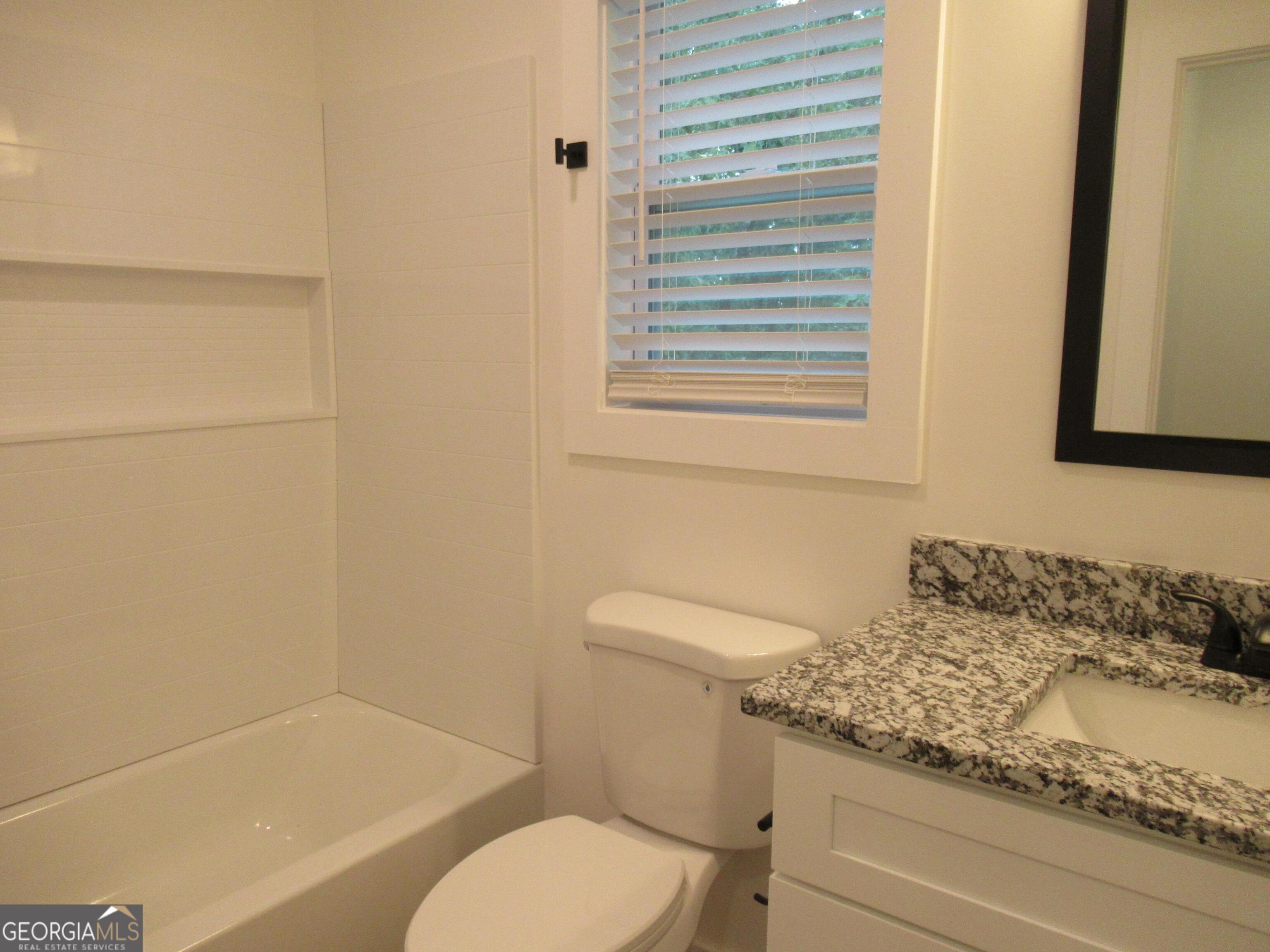 765 Old Kerns Road Dawsonville, GA 30534 - Photo 28 of 36 a bathroom with a granite countertop toilet sink and mirror