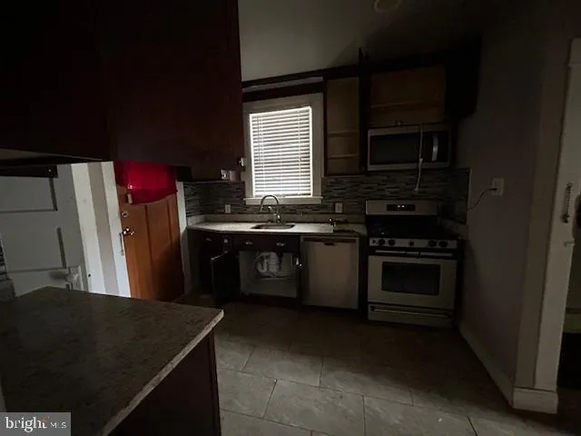 a kitchen with stainless steel appliances a stove a sink and a microwave