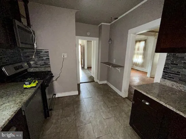 a kitchen with stainless steel appliances granite countertop a refrigerator a stove and a sink