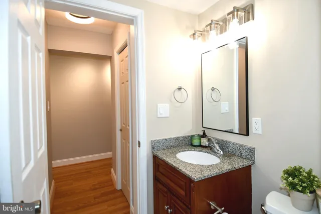 a bathroom with a granite countertop sink and a mirror
