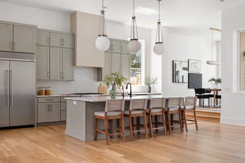 a open kitchen with stainless steel appliances granite countertop a stove and chairs