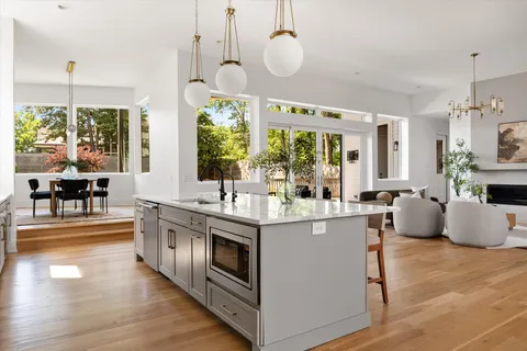 a kitchen with stainless steel appliances granite countertop white cabinets and a stove top oven