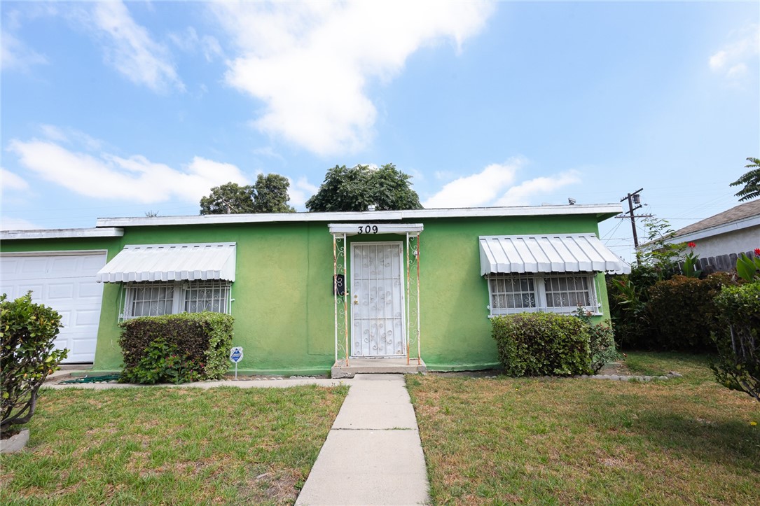 309 West Reeve Street Compton, CA 90220 - Photo 2 of 37 a front view of a house with garden