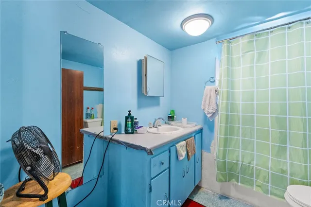 a bathroom with a sink mirror and a toilet