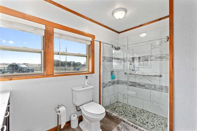a bathroom with a toilet and a shower